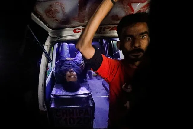 Rescue workers move an injured in the aftermath of an attack on a police station in Karachi, Pakistan on February 17, 2023. (Photo by Akhtar Soomro/Reuters)