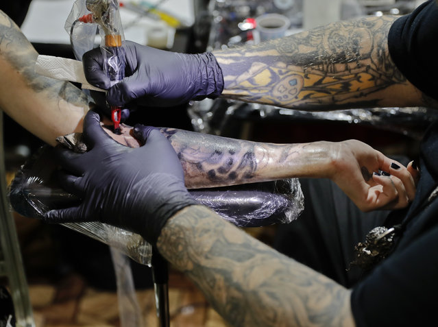 Tattoo artist Paul Booth of the United States works during the International Tattoo Convention Bucharest 2016 in Bucharest, Romania, Sunday, October 16, 2016. (Photo by Vadim Ghirda/AP Photo)