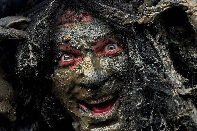 Joel Hicks, who was raising money for the “Always With a Smile” charity, takes part in the Maldon Mud Race in Essex, England, on May 5, 2013. The race originated in 1973 and involves competitors racing around a course on the mudbanks of the river Blackwater at low tide. (Photo by Dan Kitwood/Getty Images)