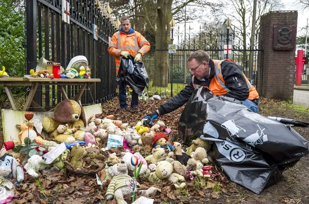 Stuffed animals are removed by municipal workers from the entrance of the Korporaal van Oudheusden barracks where the victims' bodies of the Malaysia Airlines MH17 plane crash in eastern Ukraine are identified, in Hilversum, The Netherlands, December 22, 2014. (Photo by Lex van Lieshout/EPA)