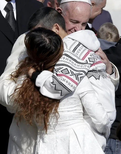 Pope Francis embraces a mother and her sick child during the weekly audience in Saint Peter's Square at the Vatican November 11, 2015. (Photo by Max Rossi/Reuters)