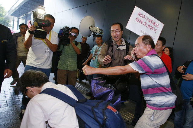 A pro-democracy protester, left, falls as he scuffled with pro-Beijing supporters, right, outside the Legislative Council in Hong Kong, Wednesday, October 19, 2016. Tensions flared at Hong Kong's legislature Wednesday as pro-Beijing lawmakers prevented a pair of newly elected representatives advocating independence for the Chinese region from getting a second chance at taking their oaths. (Photo by Kin Cheung/AP Photo)