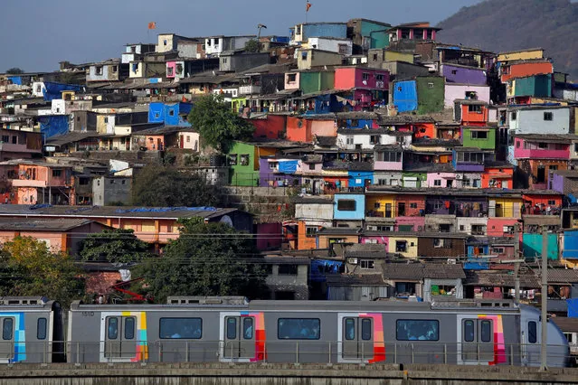 A metro train moves past a cluster of houses at the Asalpha slum in Mumbai, India, April 12, 2018. (Photo by Francis Mascarenhas/Reuters)