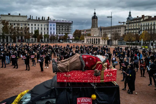 A figurin of Santa Klaus is displayed on a fake coffin as shop owners rally to call for the reopening of their stores closed as part of measures taken by the government to close their establishments to curb the spread of the covid-19 pandemic on November 16, 2020 in Lyon. (Photo by Jeff Pachoud/AFP Photo)