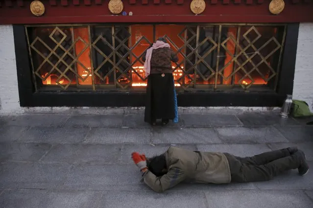 Pilgrims pray outside the Jokhang Temple in central Lhasa, Tibet Autonomous Region, China early November 20, 2015. (Photo by Damir Sagolj/Reuters)