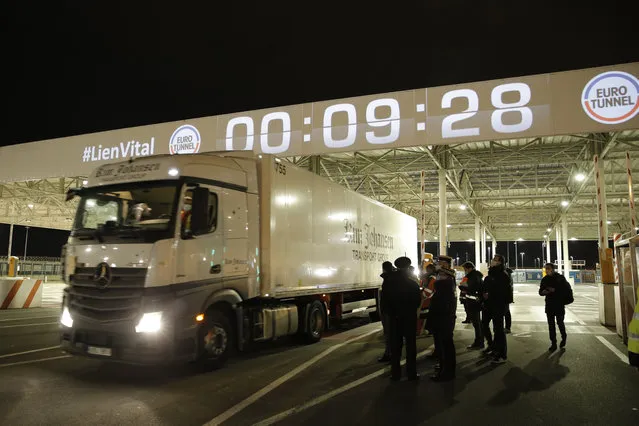 People watch the first truck, from Estonia, entering the Eurotunnel terminal Friday, January 1, 2021 in Coquelles, northern France. Eleven months after Britain's formal departure from the EU, Brexit becomes a fact of daily life on Friday, once a transition period ends and the U.K. fully leaves the world's most powerful trading bloc. (Photo by Lewis Joly/AP Photo/Pool)
