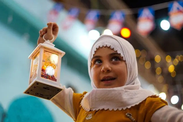 Children hold “Ramadan lanterns” in their hands and move around the streets of Old City of Mosul during the holy month of Ramadan in Iraq's Mosul on March 22, 2021. (Photo by Ismael Adnan Yaqoob/Anadolu Agency via Getty Images)