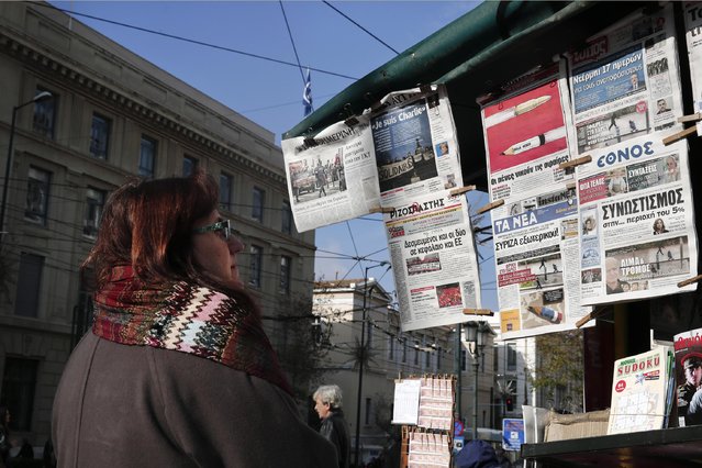 A woman reads the front pages of newspapers hanging from a kiosk, following the Wednesday's attack of Charlie Hebdo newspaper, in Athens, on Thursday, January 8, 2015. Banner headlines clockwise from the top-left read: “The freedoms of Europe are targeted”, “I am Charlie” in French, “Pens beat bullets”, “Bullets in Paris, terror in Europe”, “Blood and terror in the heart of Europe”, “Horror in Paris the cold-blooded murder of freedom of speech”. (Photo by Petros Giannakouris/AP Photo)