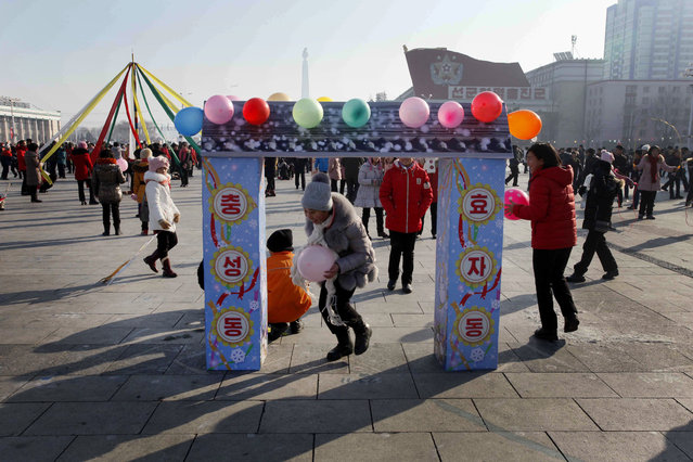 North Koreans children play as others gather on Kim Il Sung Square to celebrate the New Year on Monday, January 1, 2018, in Pyongyang, North Korea. (Photo by Jon Chol Jin/AP Photo)
