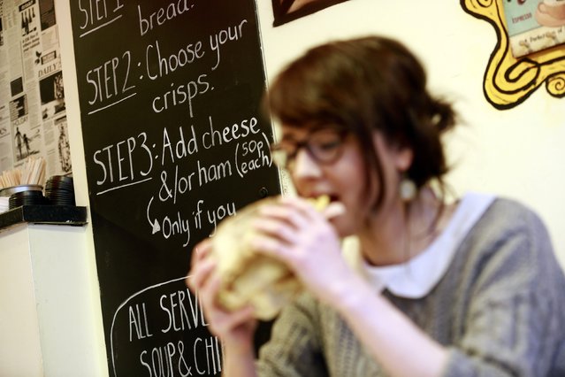 A member of staff eats a crisp sandwich in the Simply Crispy sandwich cafe in Belfast, northern Ireland January 12, 2015. (Photo by Cathal McNaughton/Reuters)