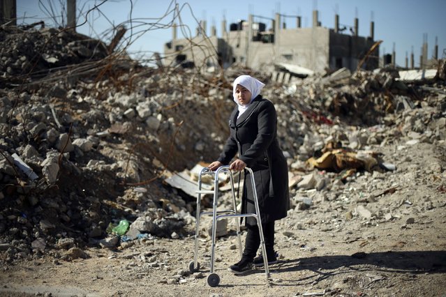 Palestinian girl Manar Al-Shinbari, 15, who lost her both legs by what medics said was Israeli shelling at a UN-run school where she was taking refuge during the 50-day war last summer, uses her walker near the ruins of her house that witnesses said was destroyed by Israeli shelling during the war, in Biet Hanoun in the northern Gaza Strip January 13, 2015. (Photo by Mohammed Salem/Reuters)