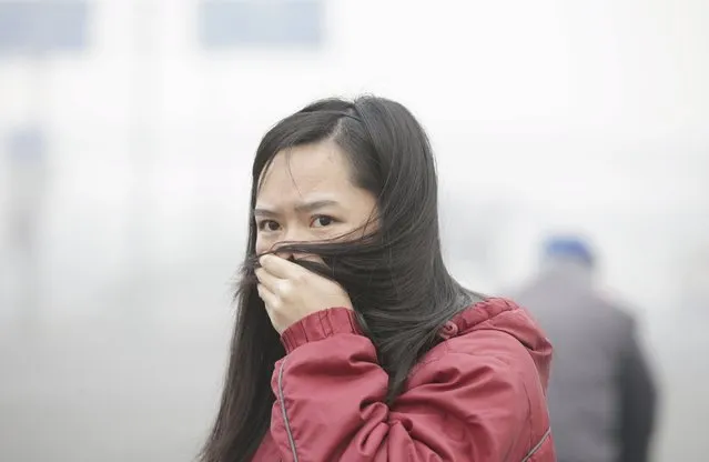 A woman covers her mouth with her hair amid heavy smog in Beijing, China, November 30, 2015. (Photo by Jason Lee/Reuters)