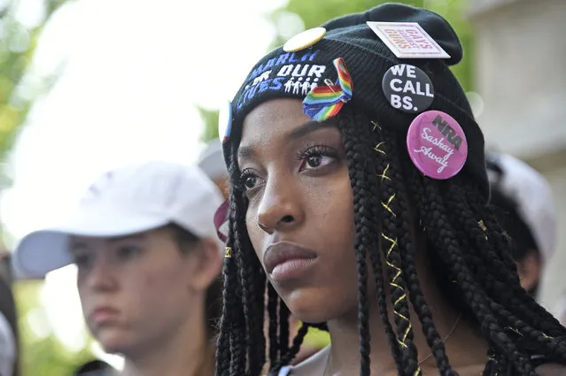 Tyra Hemans, an alumnae of Marjory Stoneman Douglas High School in Parkland, Fla., watches an art performance by Manuel Oliver at a peace rally and march, Friday, June 15, 2018, in Chicago. A group of Florida high school shooting survivors started their nationwide bus tour registering young voters to help accomplish their vision for stricter gun laws at the rally on Chicago's South Side. (Photo by Annie Rice/AP Photo)