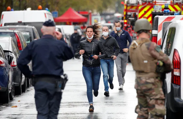 People walk towards security forces at the scene of an incident near the former offices of French magazine Charlie Hebdo, in Paris, France September 25, 2020. (Photo by Charles Platiau/Reuters)