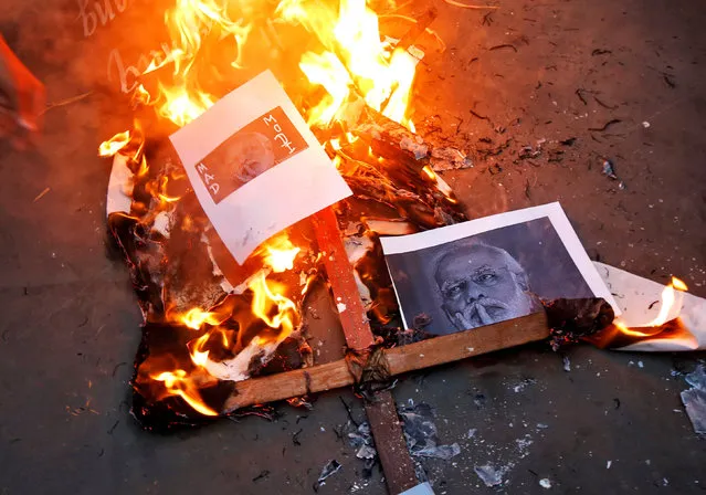Indian Prime Minister Narendra Modi’s picture burns during a protest against the Indian government’s withdrawal of 500 and 1000 Indian rupee banknotes across India, in Kolkata, India, November 9, 2016. (Photo by Rupak De Chowdhuri/Reuters)