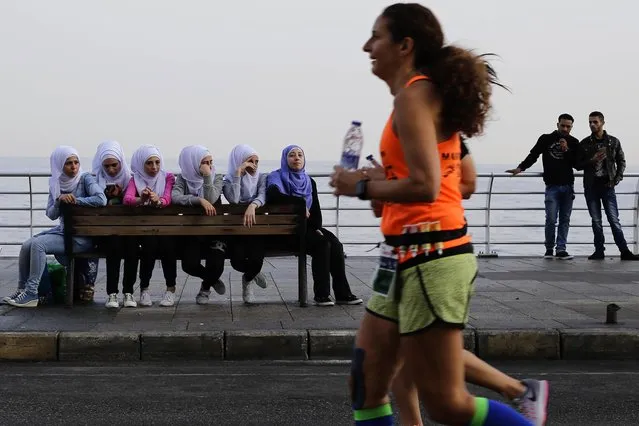 Citizens watch runners compete in the 42 kilometer (26 mile) Beirut Marathon in Beirut, Lebanon, Sunday, November 13, 2016. Thousands of runners from Lebanon and other nations are participating in this years annual Beirut Marathon. (Photo by Hassan Ammar/AP Photo)