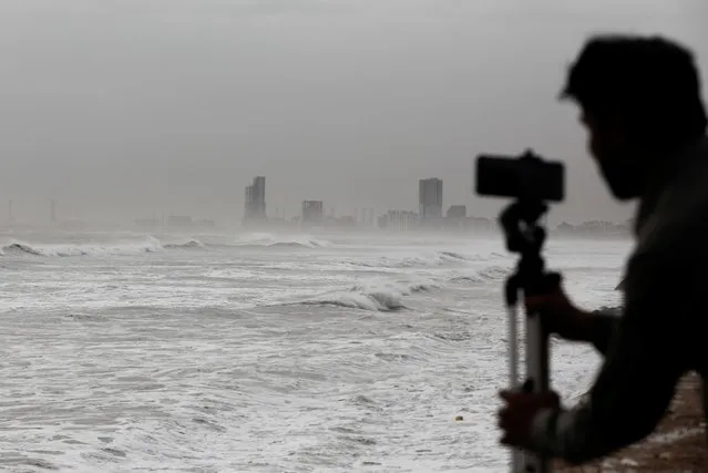 A man films the sea waves with his mobile phone, before the arrival of the cyclonic storm, Biparjoy, over the Arabian Sea, at Clifton Beach, in Karachi, Pakistan on June 13, 2023. (Photo by Akhtar Soomro/Reuters)