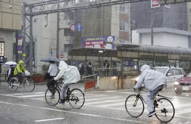 People make their way in a strong rain in Kochi, southern Japan Friday, June 2, 2023. A weakened Tropical Storm Mawar brought heavy rains to Japan’s main southern islands Friday after passing the Okinawan archipelago and causing injuries to several people. (Photo by Kyodo News via AP Photo)