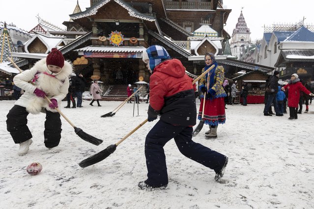 Children play ball with brooms during Maslenitsa (Shrovetide) holiday celebrations at the Izmailovsky Kremlin in Moscow, Russia, Saturday, March 13, 2021. (Photo by Alexander Zemlianichenko/AP Photo)