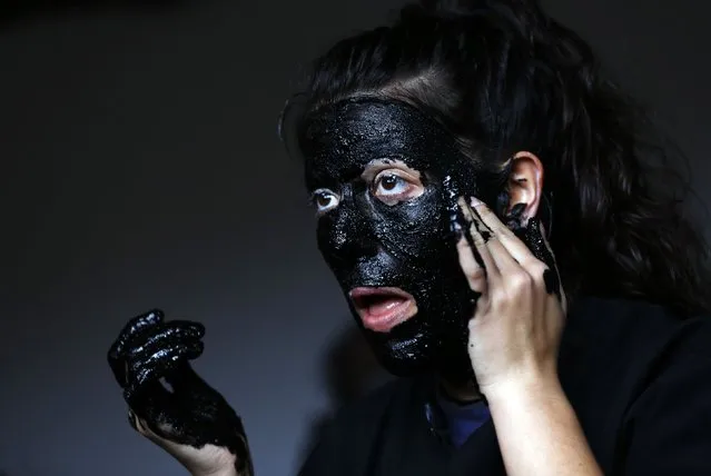 A reveller covers her face in soot and oil as he prepares to become a “Diablo de Luzon” (Luzon Devil) during carnival celebrations in the village of Luzon February 14, 2015. (Photo by Sergio Perez/Reuters)