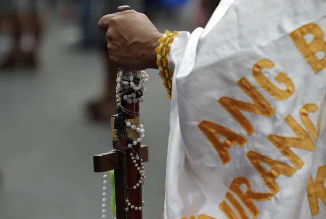 A devotee holds a cane wrapped with rosaries during a religious procession two days before the annual parade of the Black Nazarene in Manila, Philippines January 7, 2016. (Photo by Janis Alano/Reuters)