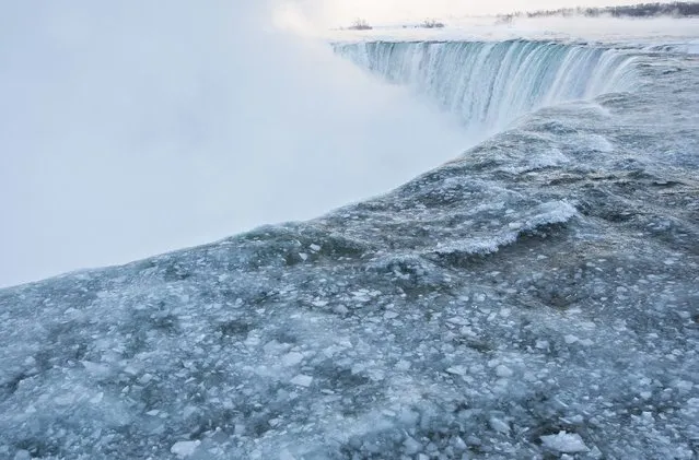 Pieces of ice flow over the Canadian “Horseshoe” Falls in Niagara Falls, Ontario, Canada, Thursday, February 19, 2015. (Photo by Aaron Lynett/AP Photo/The Canadian Press)