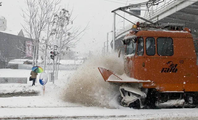 A maintenance tram clears tracks during a blizzard in Bucharest, Romania, Sunday, January 17, 2016. Large areas of Romania are affected by heavy snowfall and blizzards that disrupted road and railway traffic. (Photo by Vadim Ghirda/AP Photo)