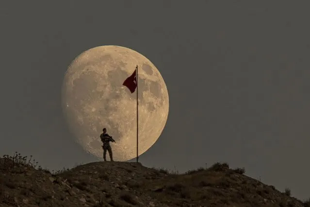A soldier is seen with the Turkish flag in front of the moon while standing guard ahead of the August 30 Turkiye's Victory Day in Van, Turkiye on August 28, 2023. August 30 is also celebrated as Turkish Armed Forces Day. (Photo by Ali Ihsan Ozturk/Anadolu Agency via Getty Images)