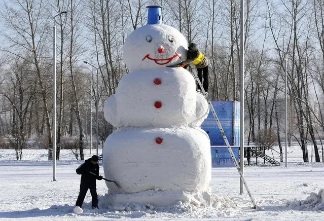Men work on a 5 meters high snowman at a park in a Siberian city of Krasnoyarsk, Russia, January 26, 2016. (Photo by Ilya Naymushin/Reuters)