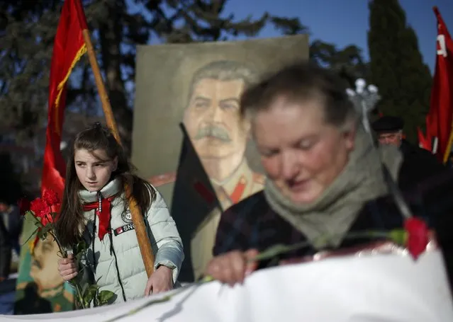 People carry flags and a portrait of Soviet dictator Josef Stalin during a rally to mark Stalin's birthday anniversary at his hometown in Gori, Georgia, December 21, 2016. (Photo by David Mdzinarishvili/Reuters)