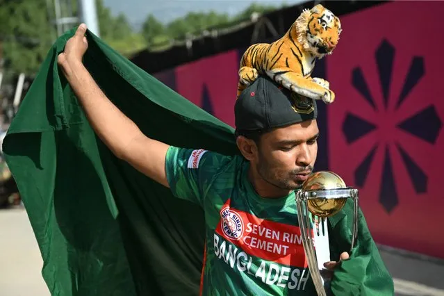 A Bangladesh fan kisses a model of 2023 ICC Men's Cricket World Cup trophy during the practice session of Bangladesh team on the eve of their 2023 ICC Men's Cricket World Cup one-day international (ODI) match against England at the Himachal Pradesh Cricket Association Stadium in Dharamsala on October 9, 2023. (Photo by Arun Sankar/AFP Photo)