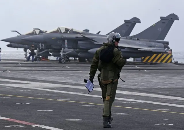 A pilot walks to his Rafale fighter jet prior to a mission in the Gulf aboard France's Charles de Gaulle aircraft carrier, January 29, 2016. (Photo by Philippe Wojazer/Reuters)