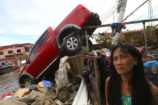 A woman pauses near a truck that was swept away by a typhoon in Tacloban, Philippines, Wednesday, November 13, 2013. Typhoon Haiyan, one of the strongest storms on record, slammed into six central Philippine islands on Friday leaving a wide swath of destruction. (Photo by Dita Alangkara/AP Photo)