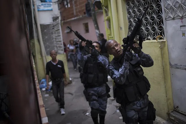 Military police officers patrol in the Roquette Pinto shantytown, part of the Mare slum complex in Rio de Janeiro, Brazil, Wednesday, April 1, 2015. (Photo by Felipe Dana/AP Photo)