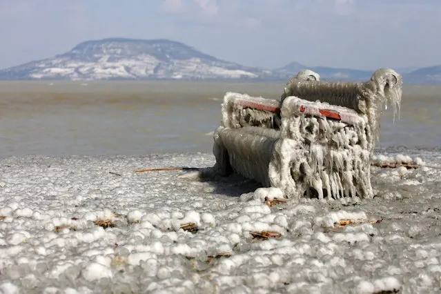 A view of an ice-covered bench on the shores of Lake Balaton in Balatonfenyves, 155 kms southwest of Budapest, Hungary, 16 March 2013, after water blown by high winds froze in subzero temperatures. (Photo by Gyorgy Varga/EPA)