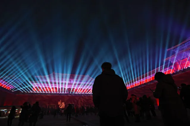 In this Tuesday, February 19, 2019, photo, visitors watch the Wumen Gate wall of the Forbidden City illuminated with lights for the Lantern Festival in Beijing. China lit up the Forbidden City on Tuesday night, marking the end of 15 days of lunar new year celebrations. It was not a Lantern Festival the last emperor, who abdicated in 1912, would have recognized. There were lanterns, but those lucky enough to snag tickets saw a laser light show and historic buildings bathed in colorful lights. Others watched from outside the vast walled compound in Beijing, from where Ming and Qing dynasty emperors ruled for five centuries. (Photo by Andy Wong/AP Photo)