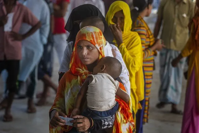 Women stand in a queue to receive the vaccine for COVID-19 in Khola Bhuyan village on the outskirts of Gauhati, India, Tuesday, September 7, 2021. (Photo by Anupam Nath/AP Photo)