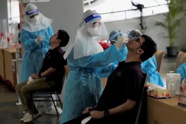 Shopping mall workers undergoes a COVID-19 swab test, during the opening at Paragon shopping mall in Bangkok, Thailand, Wednesday, September 1, 2021. Thailand to ease business lockdown measures in the capital and provinces where restrictions have been implemented since mid-July. Malls, hair salons, foot massage parlors, and parks will be allowed to re-open, as well as restaurants for dine-in services but maintained at 50% capacity. (Photo by Sakchai Lalit/AP Photo)