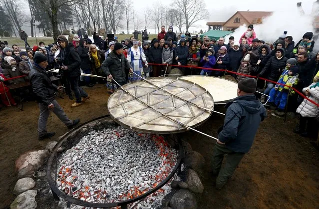 Employees prepare dranik, a potato pancake that is the national dish of Belarus, in the Sula History Park near the village of Sula, Belarus March 7, 2016. (Photo by Vasily Fedosenko/Reuters)