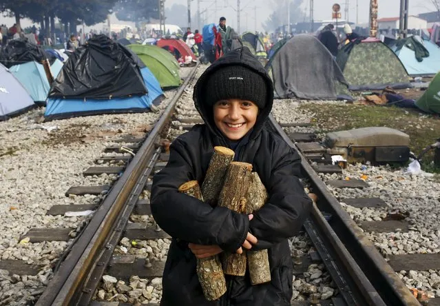 A migrant child, waiting to cross the Greek-Macedonian border, carries firewood along a railway track during a foggy early morning near the village of Idomeni, Greece March 8, 2016. (Photo by Ognen Teofilovski/Reuters)