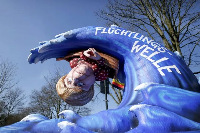 A carnival float with papier-mache caricatures featuring German Chancellor Angela Merkel, is displayed at a postponed “Rosenmontag” (Rose Monday) parade, at one location in Duesseldorf, Germany, March 13, 2016, after the original parade in February was cancelled due to severe weather. Words read “Wave of refugees”. (Photo by Ina Fassbender/Reuters)