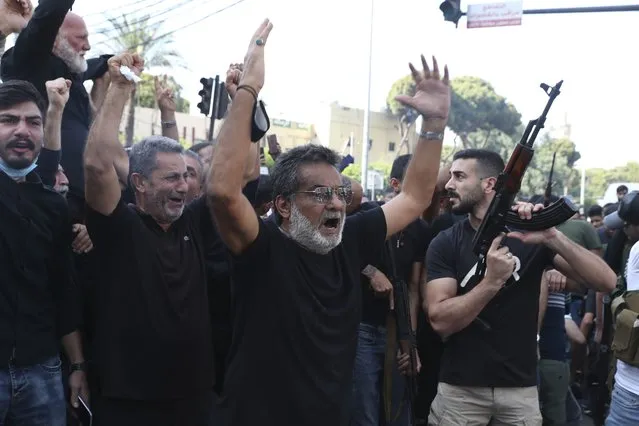 Supporters of the Shiite Hezbollah and Amal groups chant slogans during the funeral processions of Hassan Jamil Nehmeh, who was killed during Thursday clashes, in the southern Beirut suburb of Dahiyeh, Lebanon, Friday, October 15, 2021. (Photo by Bilal Hussein/AP Photo)