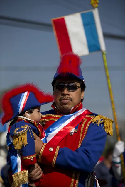 A Mexican father and son dressed as French military officers march in a parade before a reenactment of the battle of Puebla between during Cinco de Mayo celebrations in Mexico City, Tuesday, May 5, 2015. (Photo by Rebecca Blackwell/AP Photo)