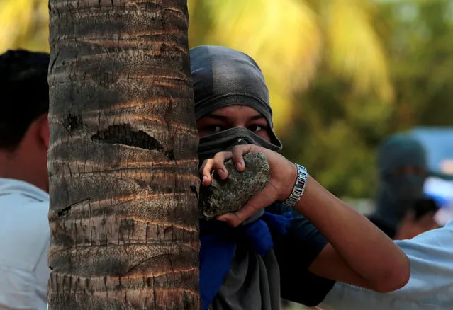 A demonstrator carries a rock during clashes with riot police officers in a protest against Nicaraguan President Daniel Ortega's government at the Metropolitan Cathedral in Managua, Nicaragua April 19, 2019. (Photo by Oswaldo Rivas/Reuters)