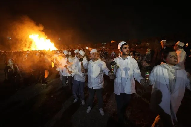 Iranian Zoroastrian youth join hands after setting a prepared pile of wood on fire as they celebrate their ancient mid-winter Sadeh festival in the outskirts of Tehran, Iran, Tuesday, January 30, 2024. (Photo by Vahid Salemi/AP Photo)
