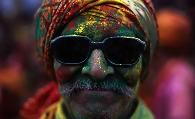 A man daubed in coloured powder poses for a picture at a temple during “Lathmar Holi” at village Nandgaon, in the northern Indian state of Uttar Pradesh, March 10, 2014. (Photo by Adnan Abidi/Reuters)