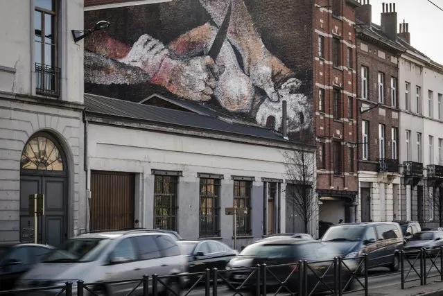 A mural of a struggling child with a knife to his neck is painted on the wall of an house in Brussels, Thursday, January 26, 2017. Depicting details from Caravaggio and Dutch Master paintings, an anonymous street artist is the talk of the town and again asks that age-old question about art: how far can it go before it outrages just too much. (Photo by Geert Vanden Wijngaert/AP Photo)