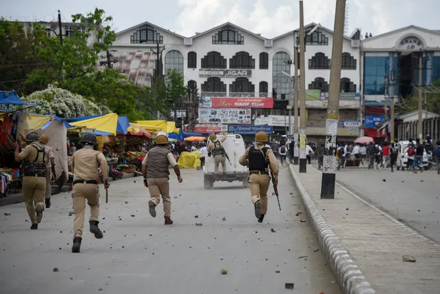 Police chase Kashmiri students after clashes during a protest following the alleged rape of a child in the region in Srinagar, India on May 15, 2019. (Photo by Idrees Abbas/Sopa Images/Rex Fetures/Shutterstock)