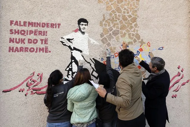 Damon Wilson head of the National Endowment for Democracy (NED), right, and a group of members of Artlords paint a wall mural in Tirana, Albania, Thursday December 16, 2021. A group of Afghan artists evacuated after the Taliban came to power in their homeland on Thursday painted a mural in the Albanian capital to show their gratitude to Albania and loudly calling on the international community not to forget their brethren back home. The sign reads “Thank you, Albania! We shall not forget”. (Photo by Franc Zhurda/AP Photo)