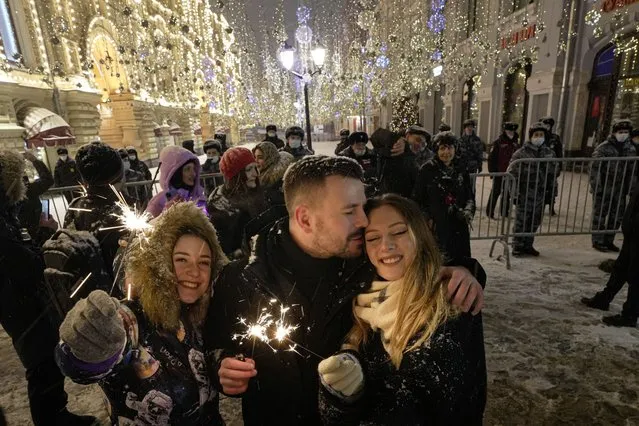 People celebrate the New Year in Nikolskaya street near an empty Red Square due to pandemic restrictions during New Year celebrations in Moscow, Russia, Saturday, January 1, 2022. Russia's state coronavirus task force has registered a total of about 10.5 million confirmed infections and 308,860 deaths, but the state statistics agency that uses broader criteria in its tallying system has reported nearly 626,000 virus-linked deaths in Russia since the start of the pandemic. (Photo by Alexander Zemlianichenko Jr.AP Photo)
